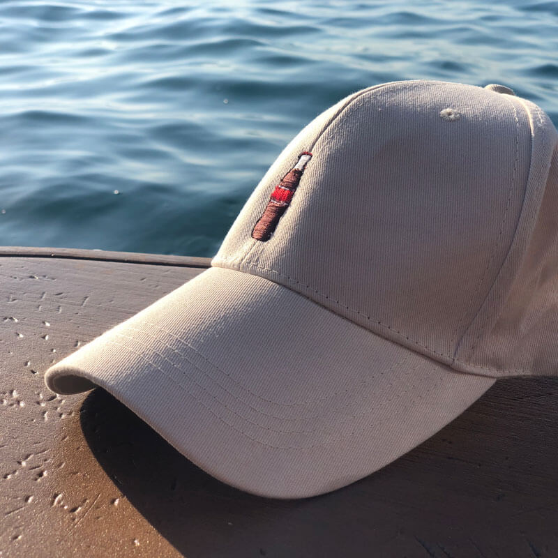 قبعة بتصميم كولا مع الأحرف الأولى