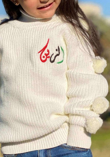 سترة بيضاء منفوشة مزينة بالكرات الصوفية
