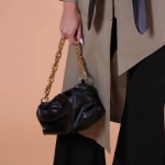 صورة حقيبة كتف سوداء وذهبية للنساء