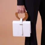 صورة حقيبة يد بيضاء بمقبض خشبي للنساء